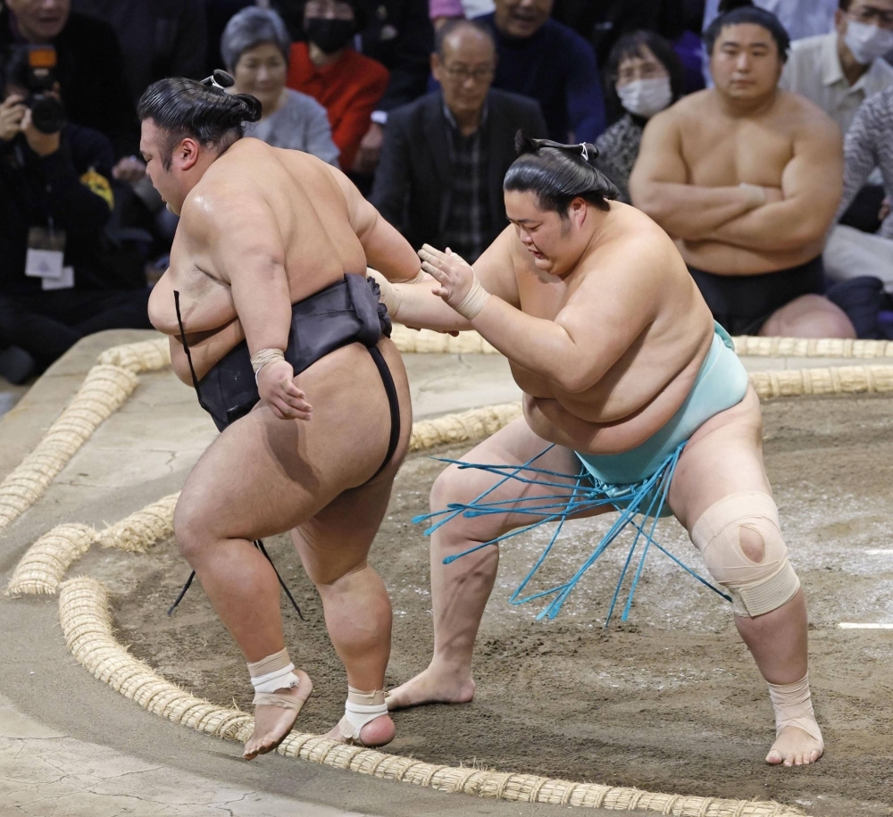 Kotonowaka pushes Takakeisho out of the ring to keep pace with the leaders at the Kyushu Grand Sumo Tournament on Wednesday in Fukuoka. 