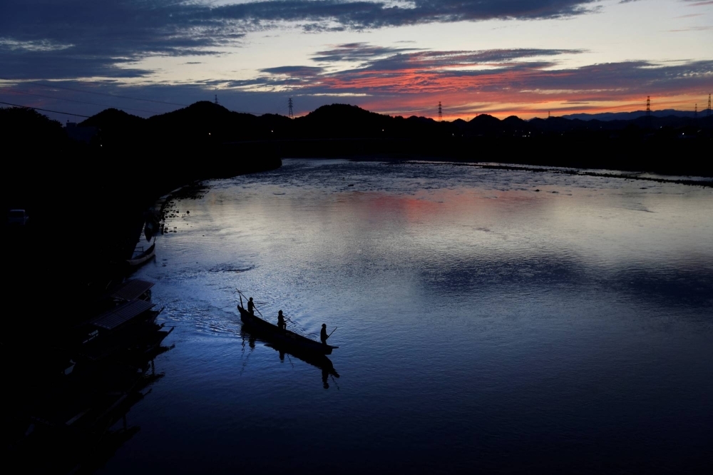 Адачи, его сын Тоитиро и рулевой Наоки Адачи отправляются ловить бакланов на реке Нагара 9 сентября.