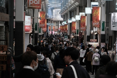 Pedestrians walk past stores in the Koenji district in Tokyo on Oct. 29.