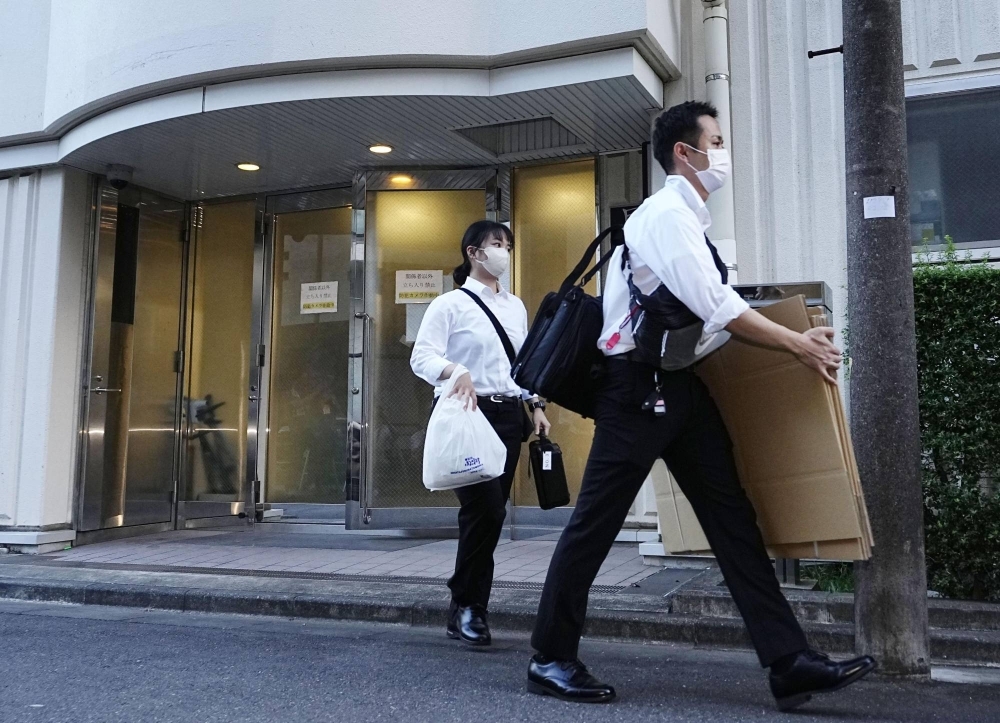 Police leave the dormitory of Nihon University's American football team in Tokyo after finishing the search in August. 