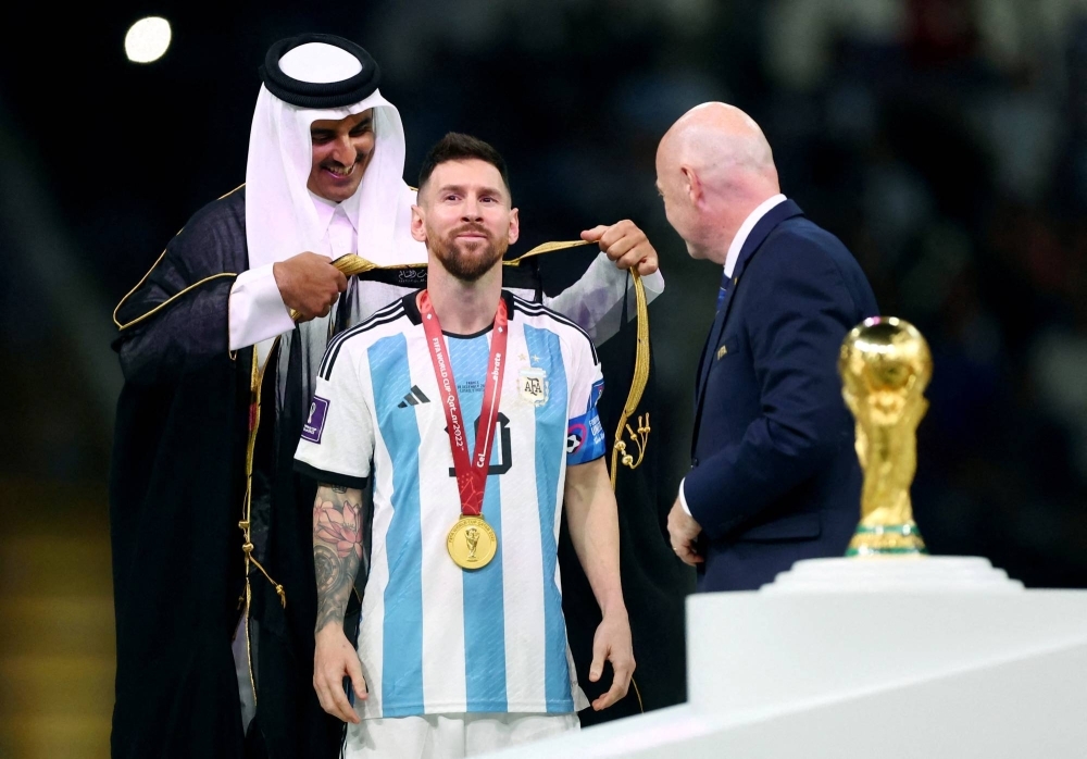 Sheikh Tamim bin Hamad Al Thani, emir of Qatar, presents Argentina's Lionel Messi with a traditional robe after the 2022 World Cup final in Lusail, Qatar, on Dec. 18, 2022.