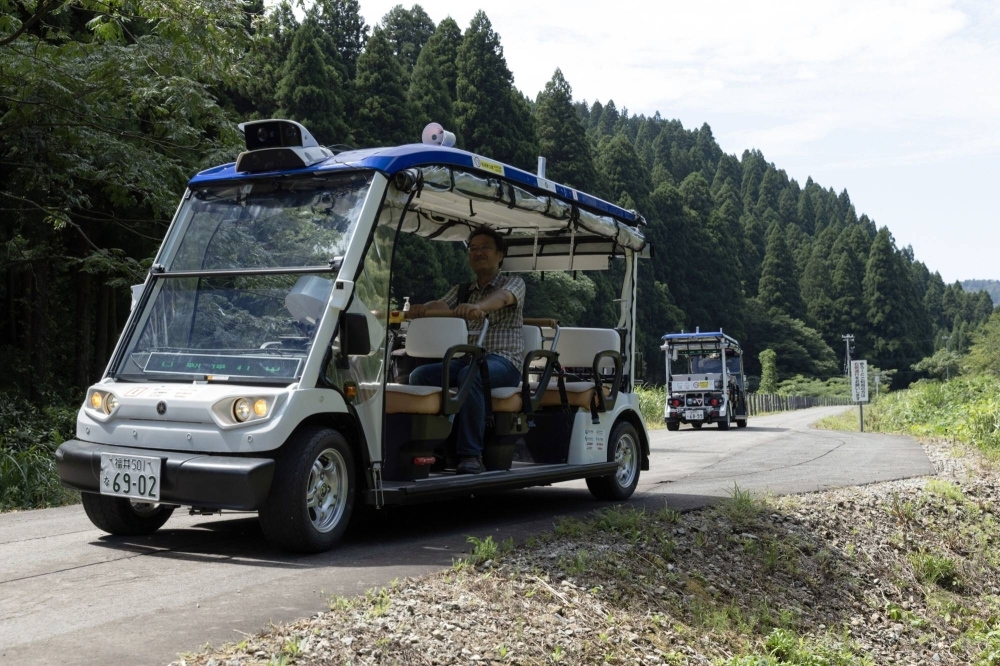 Self-driving vehicles featuring Level 4 capabilities, which means they can handle all driving tasks, in Eiheiji, Fukui Prefecture, in August