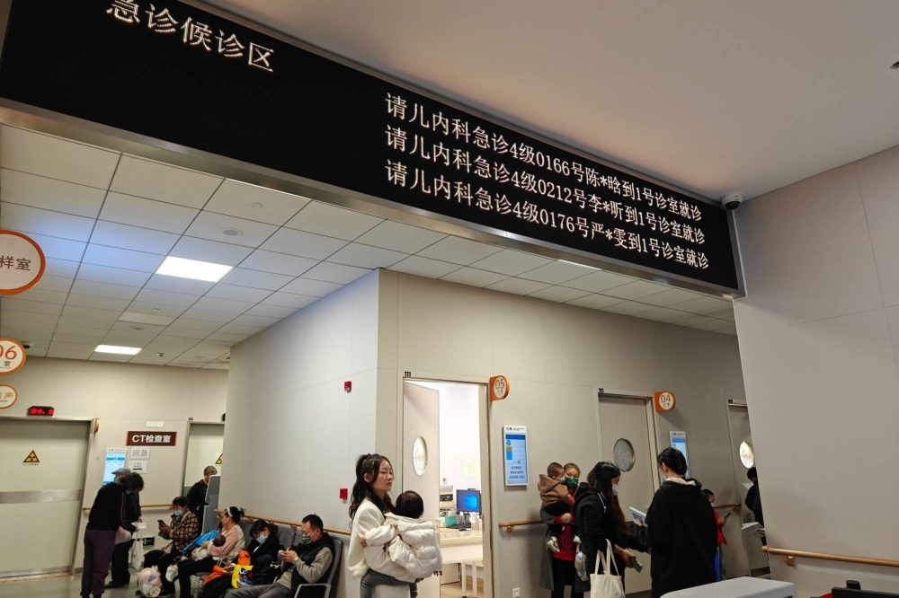 Parents take their children to see a doctor at the pediatric emergency department of a hospital in Shanghai on Nov. 14