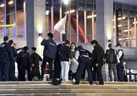 A photo supplied by a witness shows police officers investigating a site near the K-Arena Yokohama music venue in Yokohama after a woman was stabbed on Thursday. | Kyodo