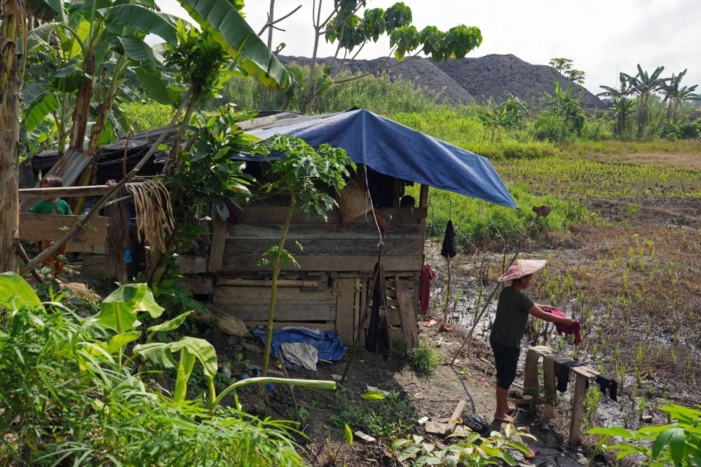 Coal stockpiles near homes and rice fields in North Kalimantan. Coal stockpiles near homes and rice fields in North Kalimantan.