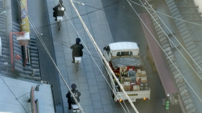 Heidrun Holzfeind documents urban and rural scenes, such as two policemen on bicycles nonchalantly rolling down a street, in her video piece "The 49th Year." The footage is presented alongside incarcerated New Left group leader Toshihiko Kamata’s writings about Japan’s highly supervised society in the exhibition "News from K."