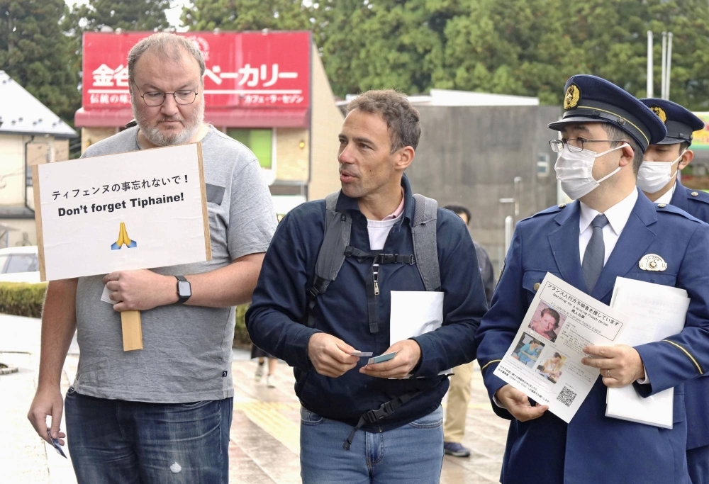 Damien Veron (center) attempts to gather information on the disappearance of his sister, Tiphaine Veron, in front of Tobu Nikko Station in Nikko, Tochigi Prefecture, last month. 