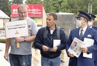 Damien Veron (center) attempts to gather information on the disappearance of his sister, Tiphaine Veron, in front of Tobu Nikko Station in Nikko, Tochigi Prefecture, last month.  | Kyodo 