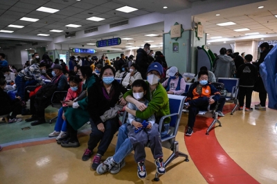 Children and their parents wait at an outpatient area at a children's hospital in Beijing on Thursday.