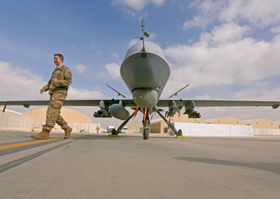 A U.S. service member passes in front of an MQ-9 Reaper drone in 2018. The U.S. military in Japan has relocated its reconnaissance drone operations unit to Okinawa, despite local objection.