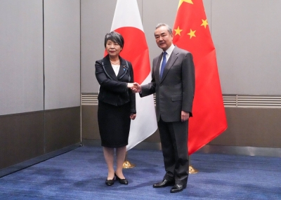 Foreign Minister Yoko Kamikawa shakes hands with her Chinese counterpart, Wang Yi, during bilateral talks in Busan, South Korea, on Saturday evening.