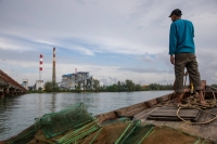 Hang Dara, an electrician-turned-fisherman, passes the two active coal-fired power plants in Sihanoukville’s Steung Hav district. | ANTON L. DELGADO
