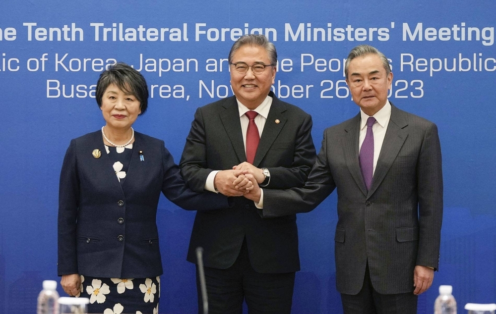 Foreign Minister Yoko Kamikawa, South Korean Foreign Minister Park Jin (center) and Chinese top diplomat Wang Yi pose for a photo ahead of trilateral talks in Busan, South Korea, on Sunday.