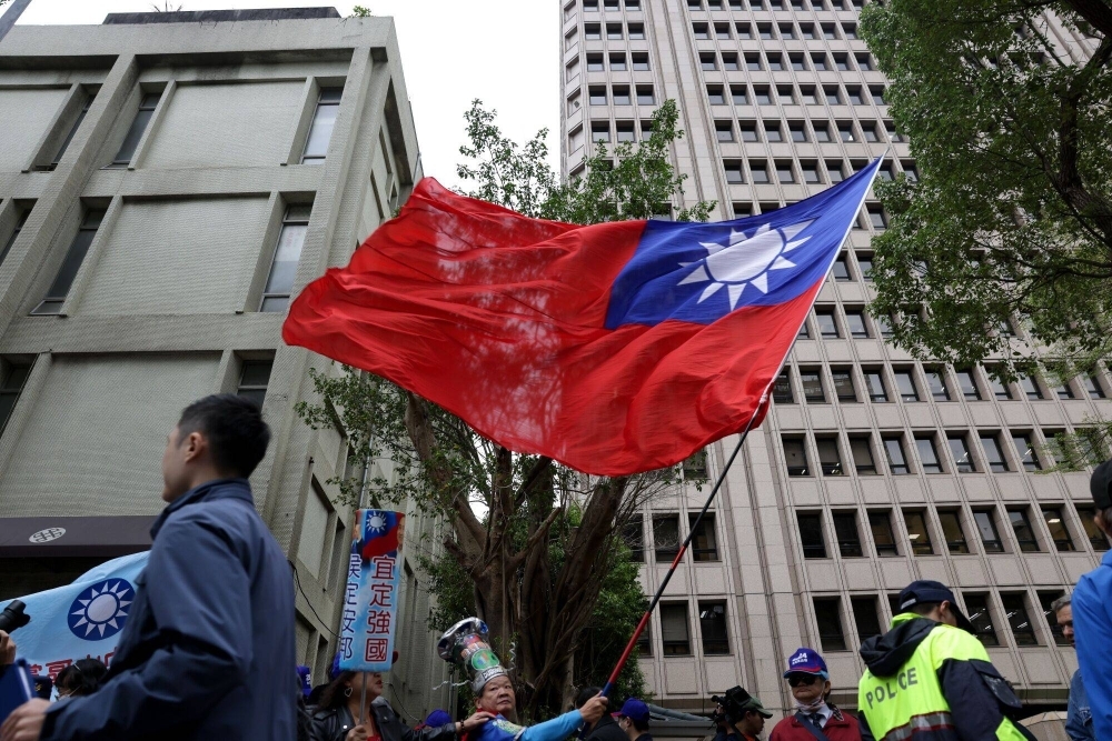 A supporter of the Kuomintang, Taiwan's main opposition party, waves the island's flag outside the Central Election Commission office in Taipei on Friday.