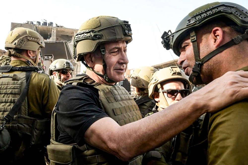 Israeli Prime Minister Benjamin Netanyahu (center) meets soldiers at undisclosed location in the Gaza Strip on Sunday. 