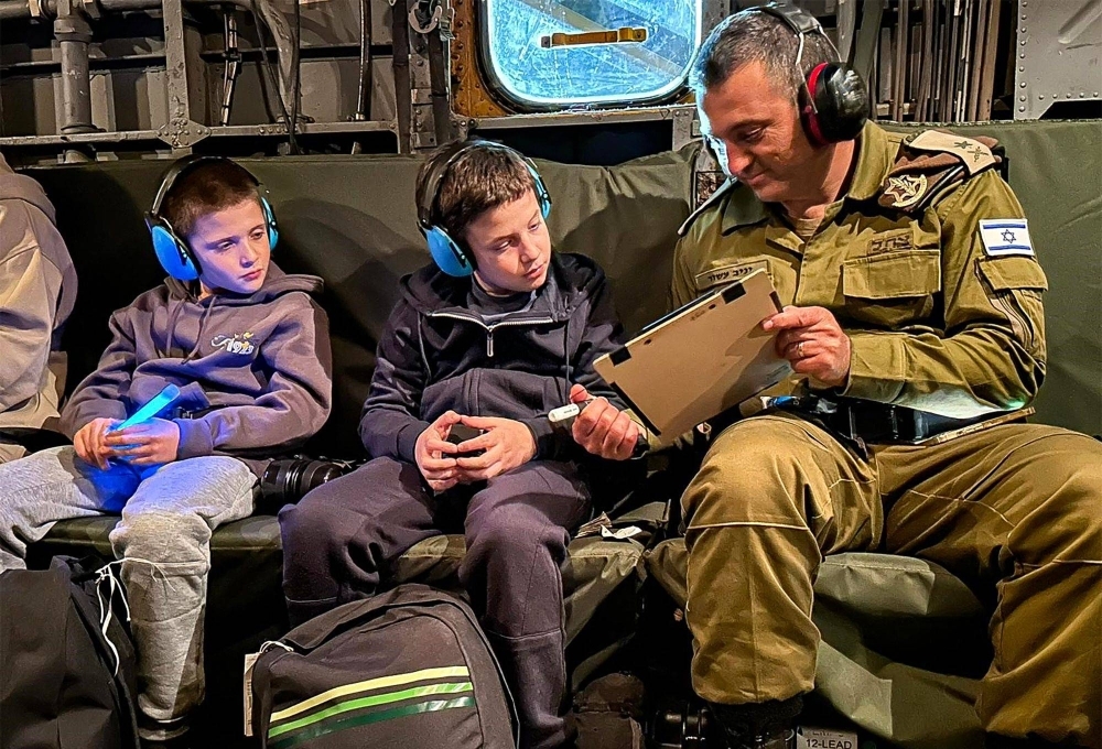 This handout picture released by the Israeli army shows hostages released by Hamas, Gal (center) and Tal Almog-Goldstein (left) being transported in a helicopter after they were released by the Palestinian militant group Hamas from the Gaza Strip on Monday.