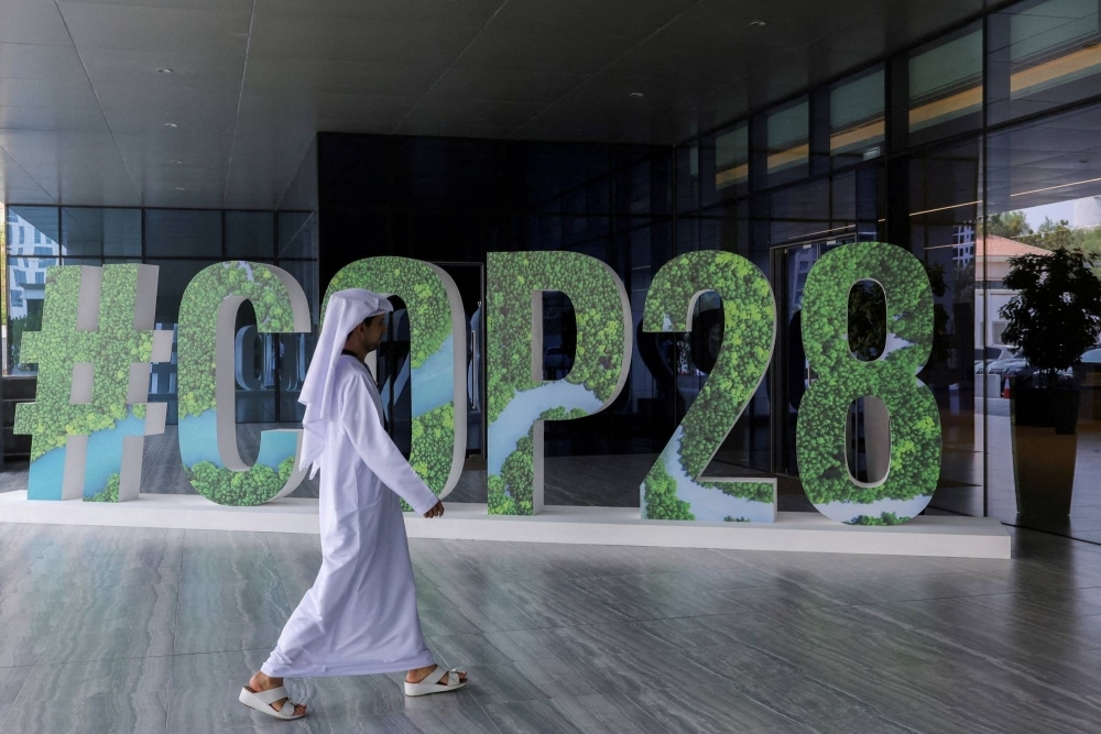 A person walks past a COP28 sign in Abu Dhabi on Oct. 1.