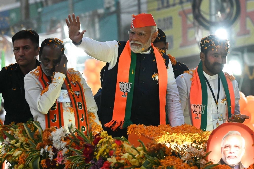 India's Prime Minister Narendra Modi (center) waves to supporters during a road show as a part of the Bharatiya Janata Party (BJP) election campaign ahead of the Telangana state assembly elections, in the city of Hyderabad on Monday.