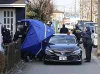 Police officers examine the area around Hiroshi Watanabe's home in Fujimino, Saitama Prefecture, on Jan. 28, 2022, after an 11-hour standoff.  | Kyodo
