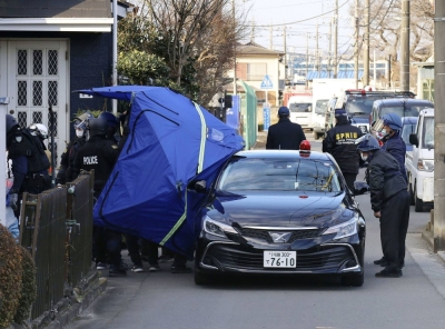 Police officers examine the area around Hiroshi Watanabe's home in Fujimino, Saitama Prefecture, on Jan. 28, 2022, after an 11-hour standoff. 