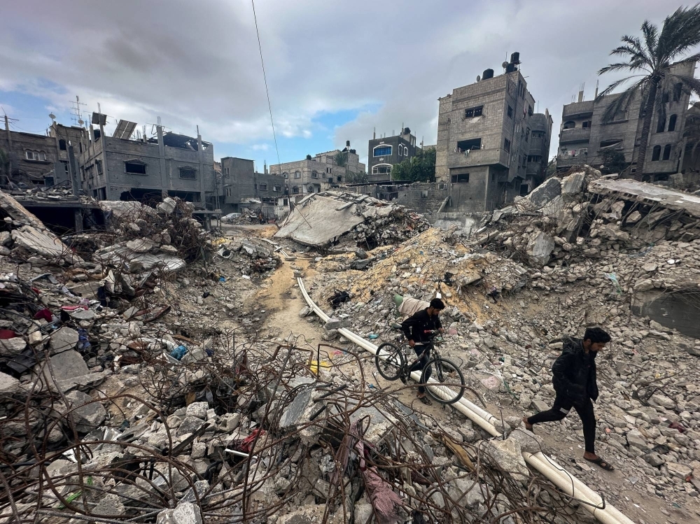 Palestinians walk among the rubble, as they inspect houses destroyed in Israeli strikes amid the temporary truce between Hamas and Israel on Monday.