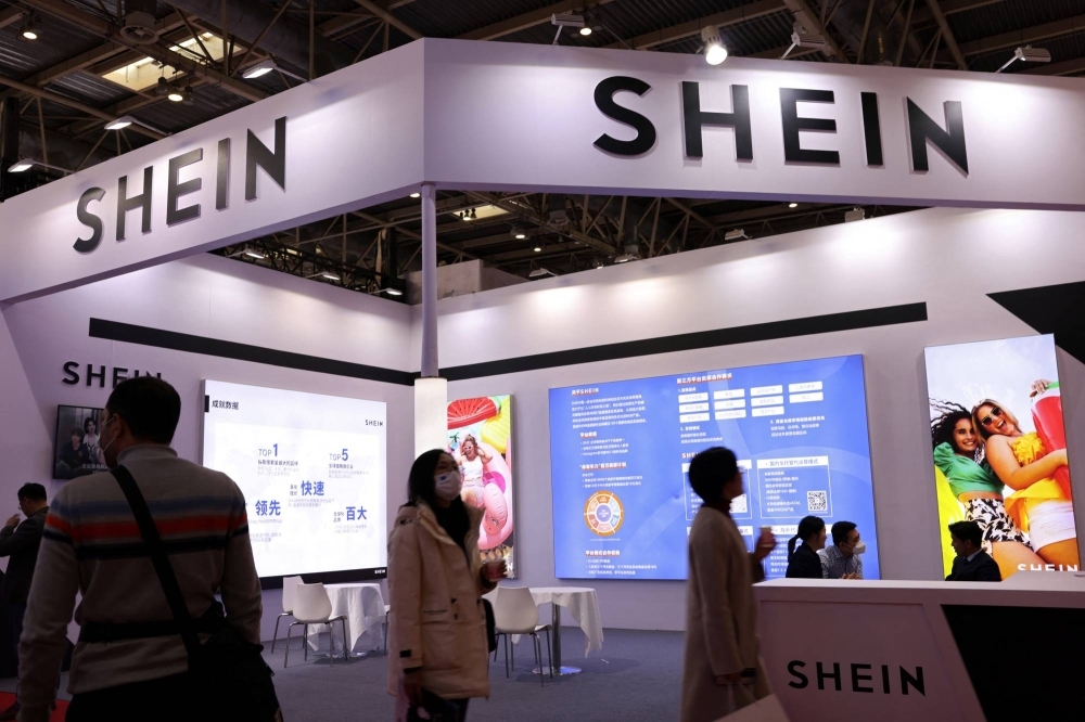 People walk past the booth of fashion retailer Shein during the first China International Supply Chain Expo (CISCE) in Beijing on Tuesday.