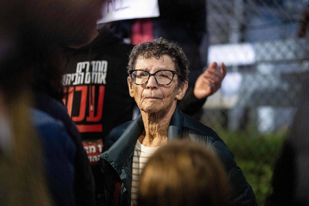 Israeli freed hostage Yocheved Lifshitz (center), 85, takes part in a protest with her family members outside the Ministry of Defense in Tel Aviv on Tuesday. Her husband Oded is reportedly still held hostage in Gaza by Hamas.