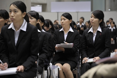 University students attend a job fair. If Japanese companies continue hiring people based on the university they graduated from, acquiring extra qualifications or reskilling won't impact candidates' job prospects.