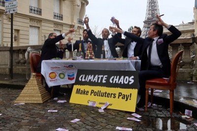 Activists dressed up like CEOs take part in a fake banquet near the Eiffel Tower in Paris on Monday where they feign the celebration of company profits over climate responsibility. 
 