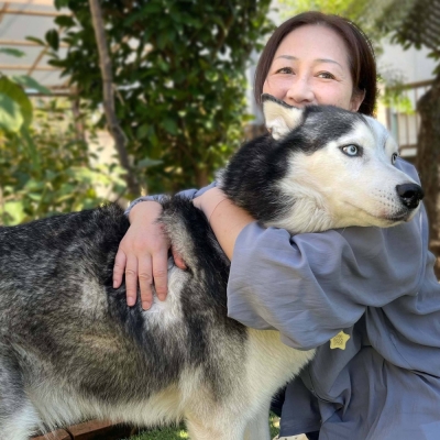 Tomoko Hongo gives Hercules a hug. The dog came to her family malnourished but he's doing well now.