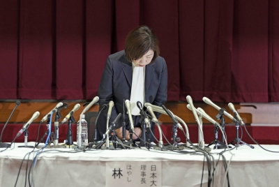 Mariko Hayashi, chairperson of Nihon University, bows her head in apology at a news conference in Tokyo on Monday.
