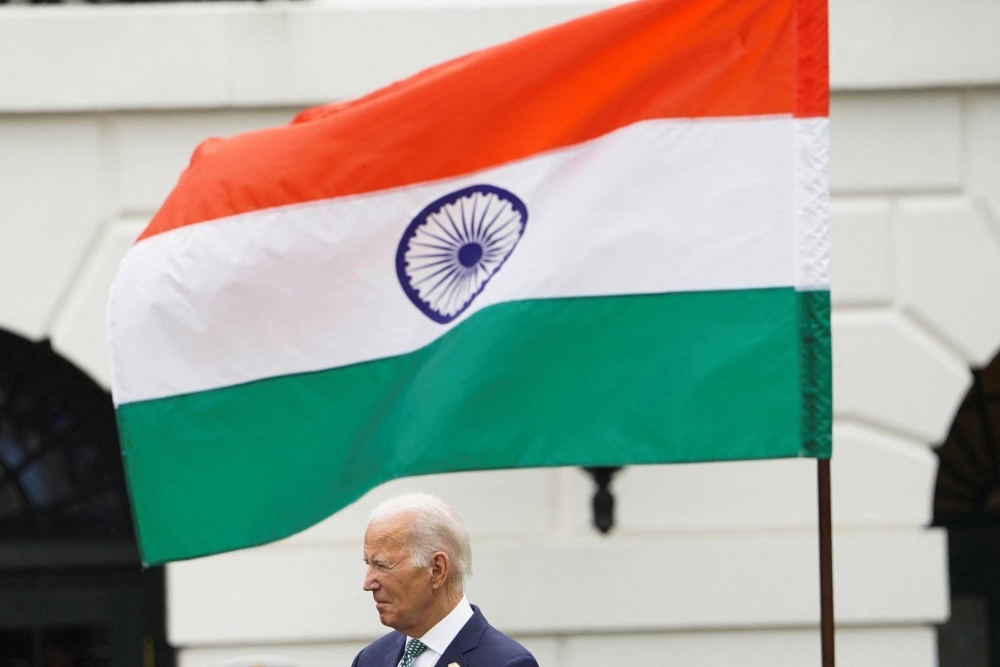 U.S. President Joe Biden stands under the flag of India during an official state arrival ceremony for India’s Prime Minister Narendra Modi on the south lawn of the White House in Washington.