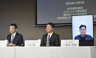 KDDI President Makoto Takahashi (left), SoftBank President Junichi Miyakawa (center) and Rakuten Mobile's Hiroshi Mikitani speak during a news conference in Tokyo on Monday. 