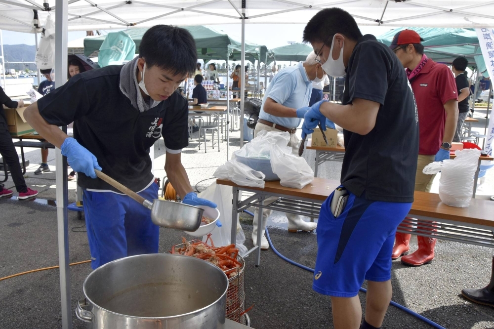 Students from Sakaiminato Comprehensive Technical High School sell crab soup on Sept. 16 at the Nakano Port Fishing Village Market in Sakaiminato, Tottori Prefecture.