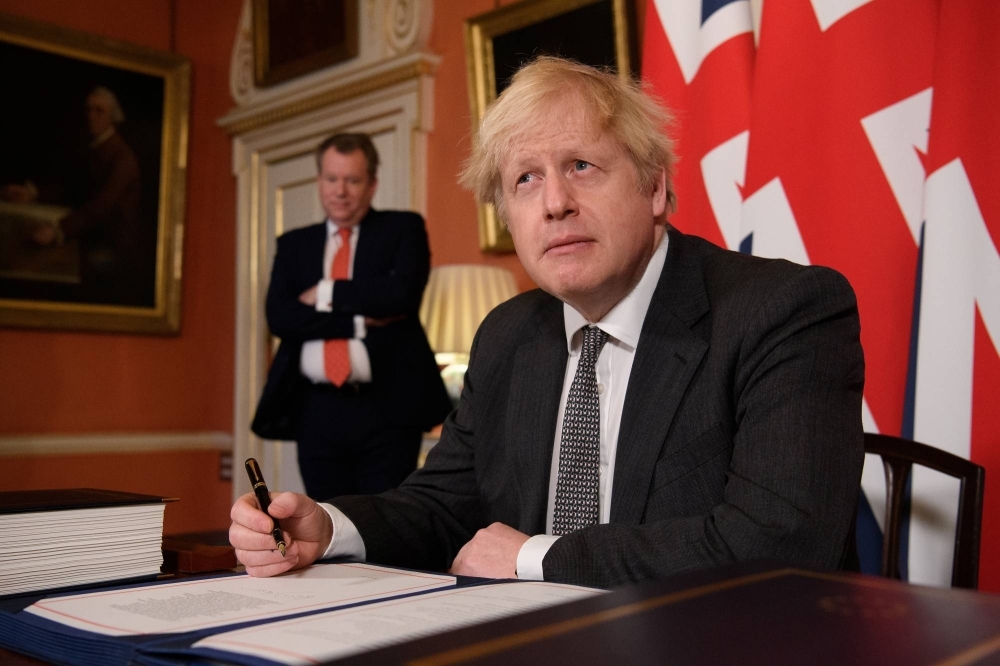 Former British Prime Minister Boris Johnson signing the Brexit trade deal with the EU in London on Dec. 30, 2020.
