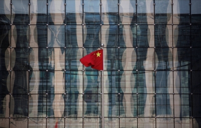 A Chinese national flag flutters at the headquarters of a commercial bank on a financial street near the People's Bank of China in Beijing.