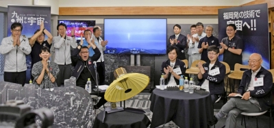 Officials from iQPS celebrate in the city of Fukuoka in June after the successful launch of a rocket carrying a small satellite developed by the firm.