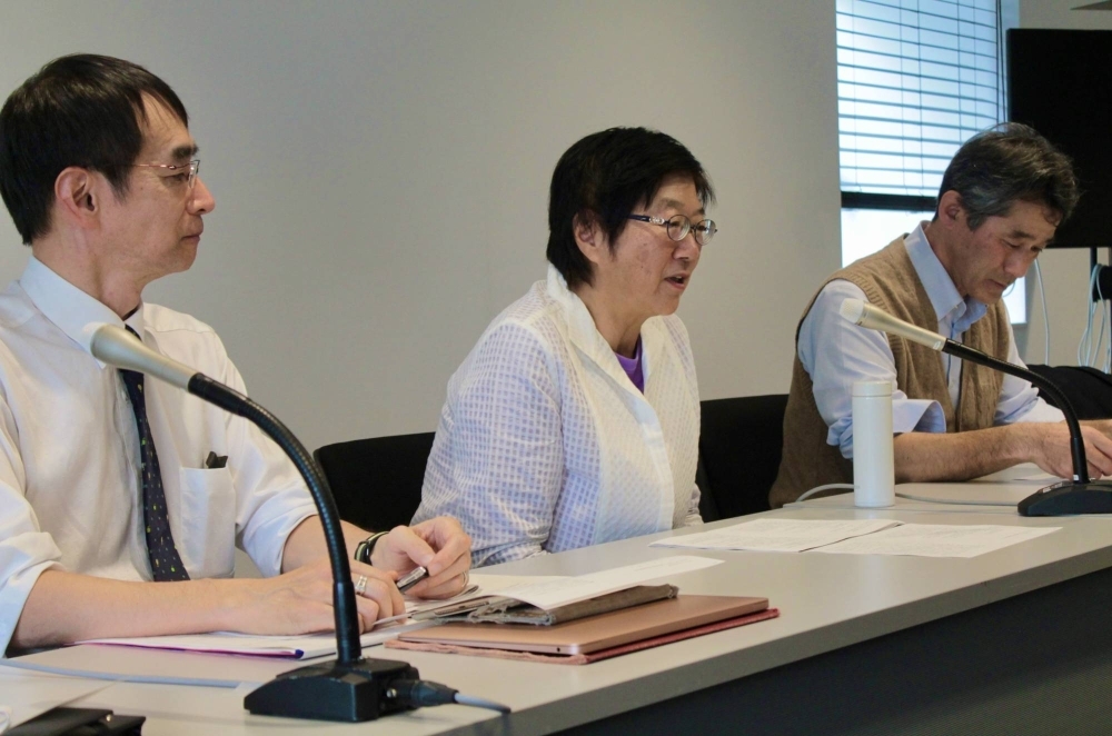 Yuri Kondo (center), the plaintiff of a dual nationality case, speaks during a news conference Wednesday in the city of Fukuoka after the Fukuoka District Court handed down a ruling on her case.