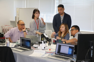 Participants at the Japan-U.S.-EU Industrial Control Systems Cybersecurity Week for the Indo-Pacific Region speak with each other during a hands-on training exercise in Tokyo on Oct. 12.