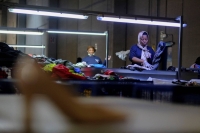 Workers organize used clothing for packaging at a warehouse near Barcelona on Aug. 1. | REUTERS