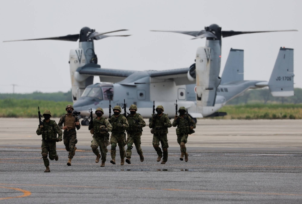 Ground Self-Defense Force personnel take part in a military drill involving a V-22 Osprey aircraft in June 2022. 