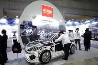 A seated attendee examines an automotive solution system using Rohm semiconductor products at the Automotive World 2018 forum in Tokyo in January 2018. | Bloomberg