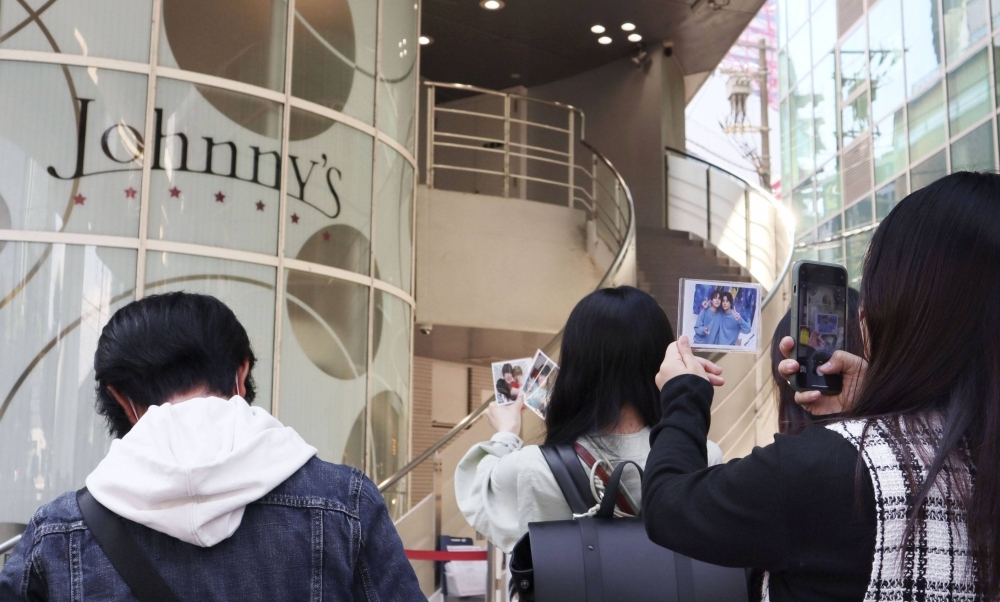 Fans in Osaka take photos as the company formerly known as Johnny & Associates removes references to its founder. The agency announced its new name, Starto Entertainment, on Friday.