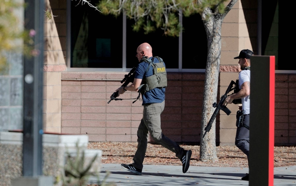 Law enforcement officers head into the University of Nevada, Las Vegas, campus amid a mass shooting on Wednesday. 