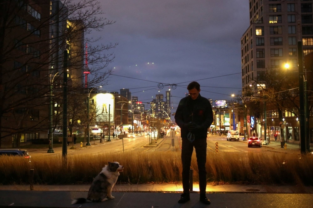 Justinas Stankus, 38, who came to Canada from Lithuania in 2019 and is studying at the University of Toronto, walks his dog in Toronto, Ontario, Canada.