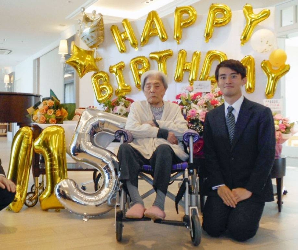 Tomiko Itooka (left) has her photo taken with Ashiya Mayor Ryosuke Takashima during a birthday celebration at her nursing home on May 23.