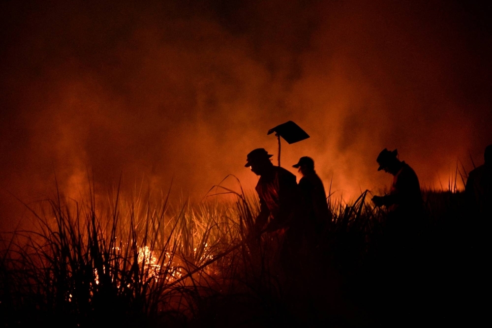 Firefighters tackle a fire in a field in San Buenaventura in the Bolivian Amazon in November.