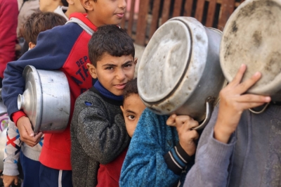 Palestinian children hold pots as they queue to receive food cooked by a charity kitchen, amid shortages in food supplies, in Rafah, in the southern Gaza Strip, on Thursday.