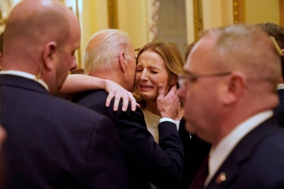U.S. President Joe Biden hugs Brittany Alkonis, wife of Lt. Ridge Alkonis, on the day of the State of the Union address to a joint session of Congress in Washington on Feb. 7.