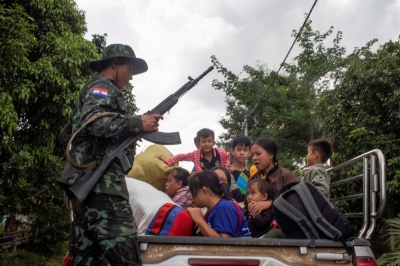 A member of the insurgent Karenni Nationalities Defence Force rescues civilians trapped amid airstrikes, during a battle to take over Loikaw in Kayah State, Myanmar, in November.